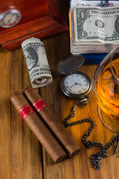 Заможний стіл чоловіка, кубинські сигари доларові банкноти, старовинний годинник і — стокове фото