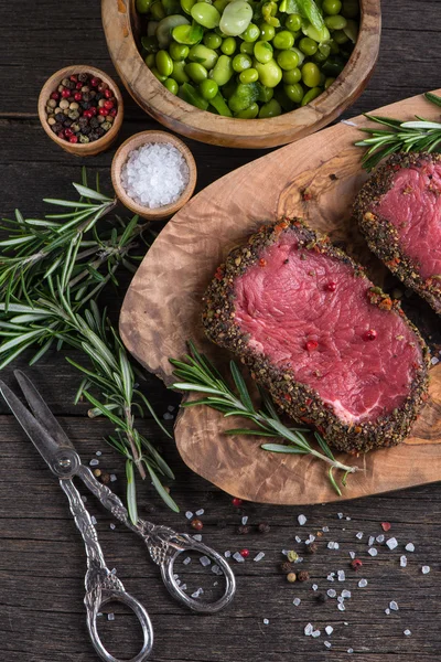 Top view on raw steak with herbs and pepper — Stock Photo, Image
