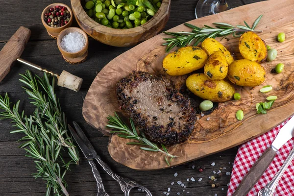 Biefstuk met geroosterde aardappelen en kruiden, bovenaanzicht — Stockfoto