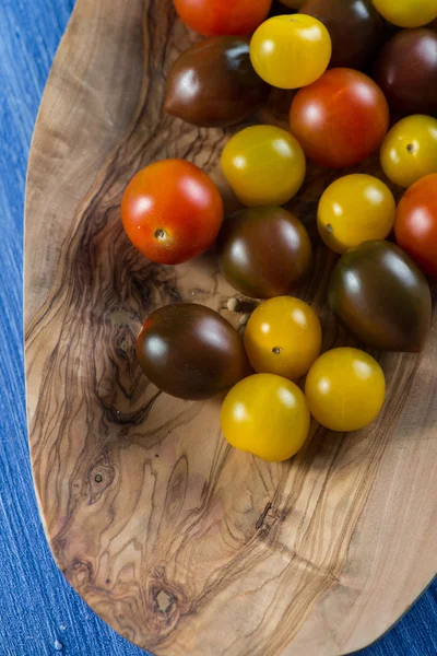 Pomodori colorati su uno sfondo di legno vivace — Foto Stock