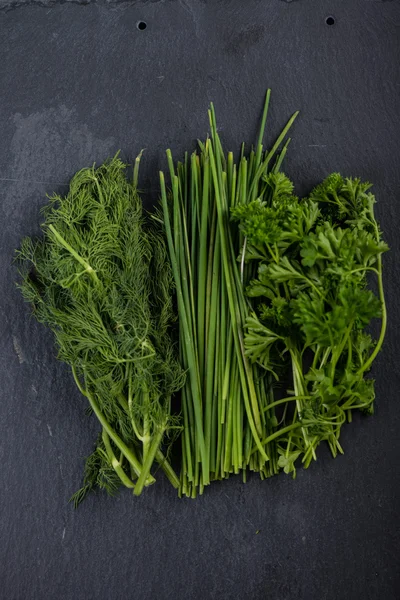 Spring garden fresh chives, parsley and dill on black slate back — стоковое фото