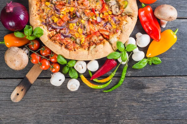 Yukarıdan ev yapımı vejeteryan pizzaya ahşap masa — Stok fotoğraf