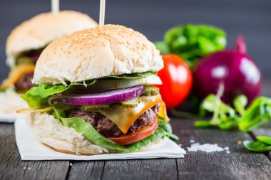 Ahşap masa üzerinde sebze ile ev yapımı hamburger