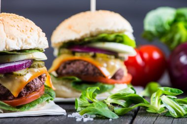 Ahşap masa üzerinde sebze ile ev yapımı hamburger
