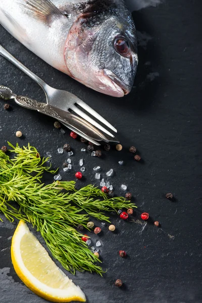 Свежая целая морская рыба с ароматическими травами, концепция приготовления пищи — стоковое фото