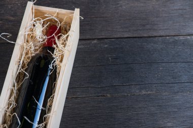 Ahşap durumda saman rustik arka plan üzerinde kırmızı şarap şişesi