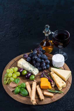 Cheese board with fresh grapes,herbs and olives clipart