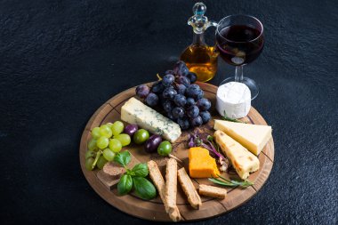 Peynir kurulu taze üzüm, otlar ve zeytin ile