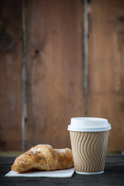 Kaffee und frisches Croissant zum Mitnehmen — Stockfoto