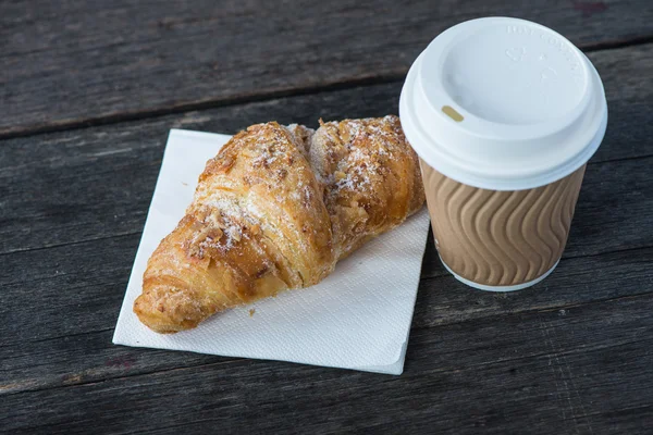 Kaffee und frisches Croissant zum Mitnehmen — Stockfoto