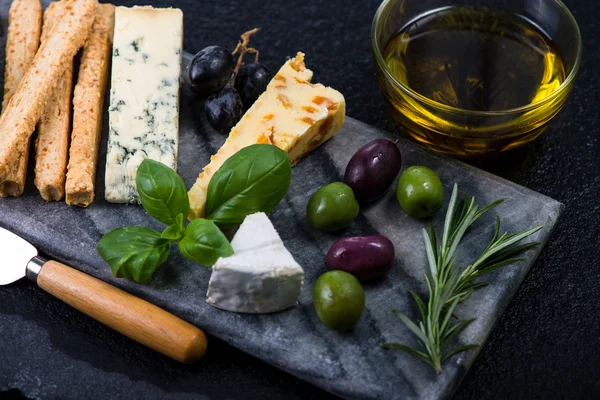 Seleção de queijo estilo Tapas com azeitonas, uvas e ervas — Fotografia de Stock