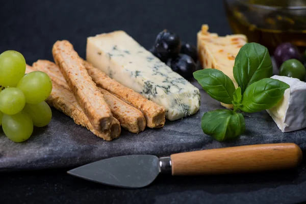 Tapas style cheese selection with olives,grapes and herbs — Stock Photo, Image