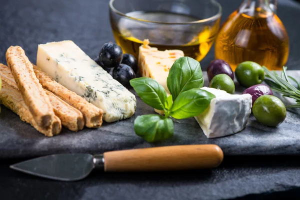 Seleção de queijo estilo Tapas com azeitonas, uvas e ervas — Fotografia de Stock