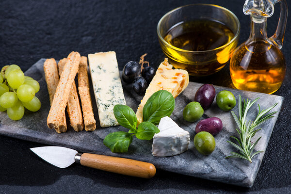 Tapas style cheese selection with olives,grapes and herbs