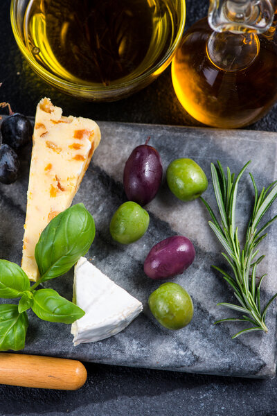 Tapas style cheese selection with olives,grapes and herbs