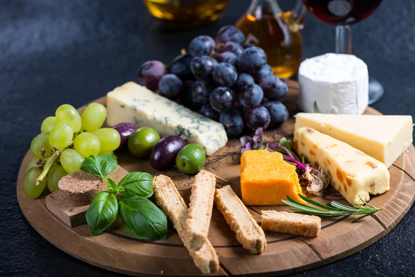 Cheese board with fresh grapes,herbs and olives — Stock Photo, Image