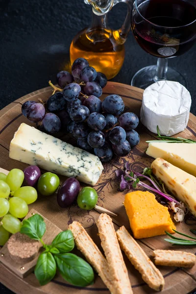 Cheese board with fresh grapes,herbs and olives — Stock Photo, Image