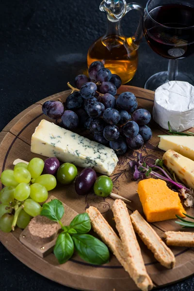 Cheese board with fresh grapes,herbs and olives — Stock Photo, Image