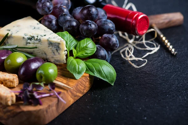 Food background,rustic board with cheese herbs and wine — Stock Photo, Image