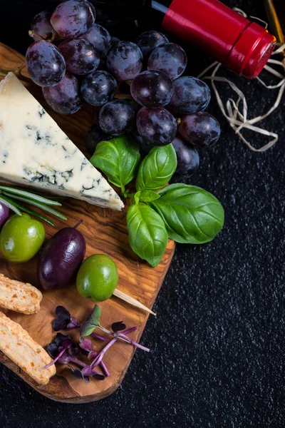 Food background,rustic board with cheese herbs and wine — Stock Photo, Image