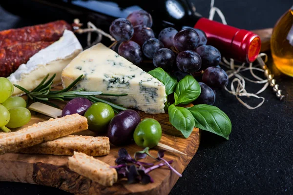 Tapas-Brett mit Käse, Oliven, Trauben und Rotwein — Stockfoto