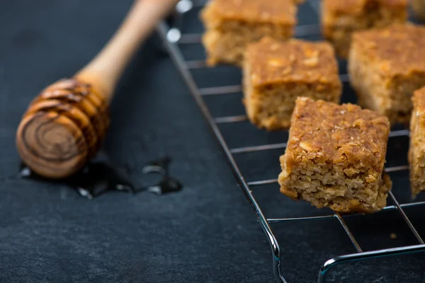 Homemade healthy flapjacks with honey on cooling rack — Stock Photo, Image