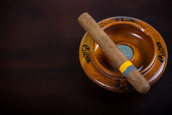 Kubańskie cygaro w popiół tacę na białym tle na drewniany bar — Zdjęcie stockowe