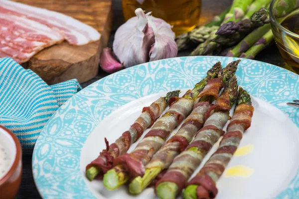 Fresh asparagus wrapped in crispy bacon or pancetta — Stock Photo, Image