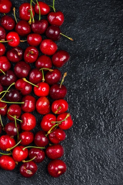 Świeżych dojrzałych wiśni organicznych na czarnym tle — Zdjęcie stockowe