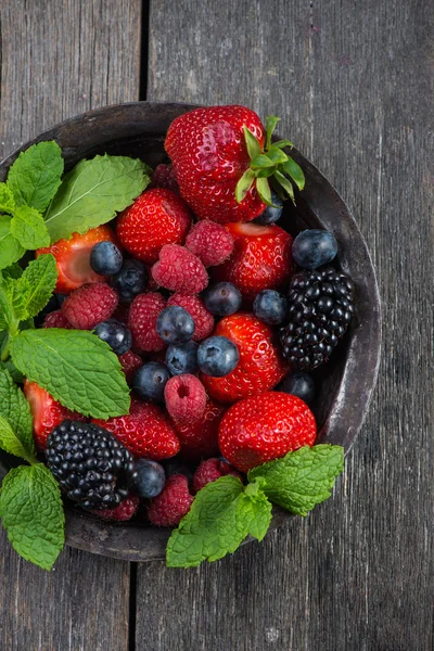 Свіжі літні ягоди з м'ятою в сільській мисці — стокове фото