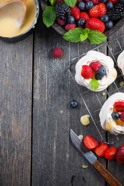 Versieren zelfgemaakte pavlova meringue met bessen fruit — Stockfoto