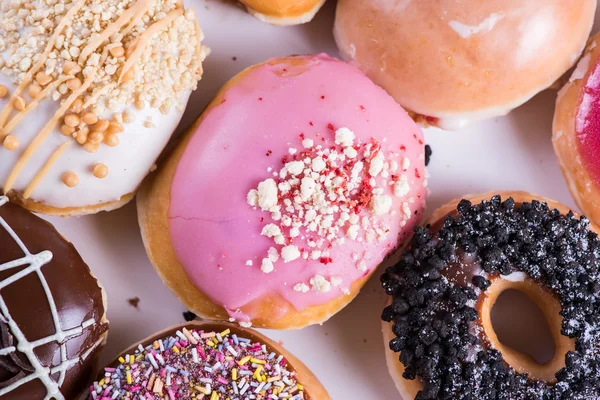 Overhead view on vibrant donuts in box — Stock Photo, Image