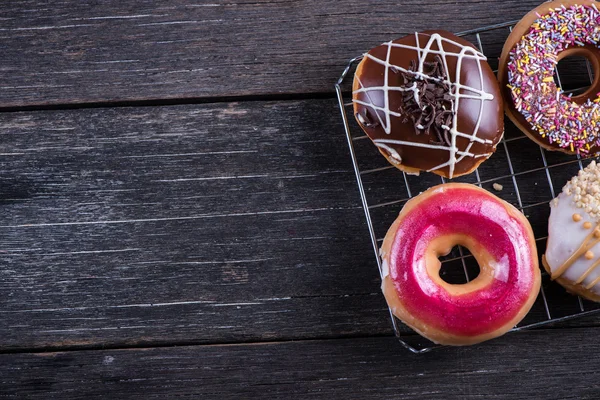 Hand decorated artisan donuts on wooden table — Stock Photo, Image