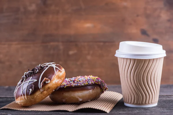 Donuts artesanais frescos e tirar café, fundo de madeira — Fotografia de Stock