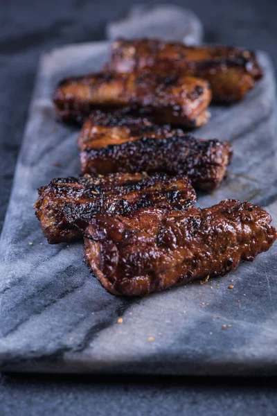 Krokante varkensvlees belly segmenten op graniet bord — Stockfoto