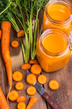 Havuç suyu ahşap arka plan üzerinde mason kavanoza