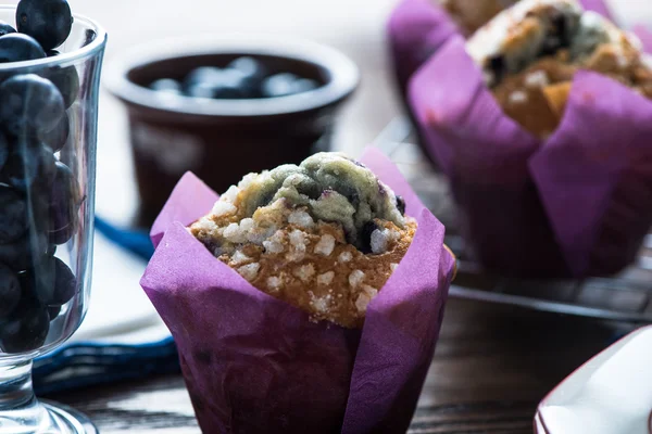 Fresh blueberry muffins served on wooden table — Stock Photo, Image