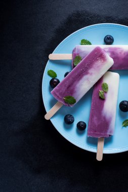 Yoğurt ve yaban mersini buzlu şeker plaka üzerinde