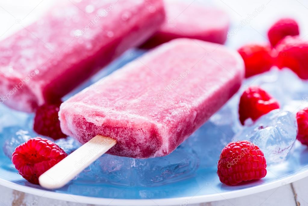 Homemade raspberry popsicles on plate