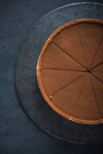 Torta de chocolate fatiado no fundo escuro — Fotografia de Stock