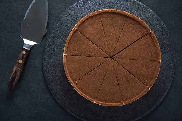 Torta de chocolate fatiado no fundo escuro — Fotografia de Stock