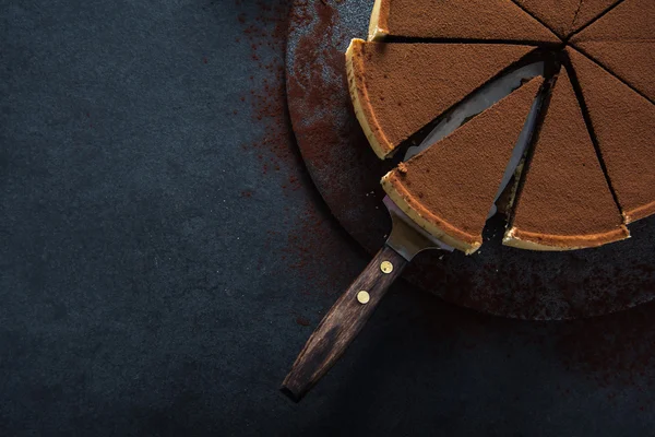 Torta de chocolate fatiado no fundo escuro — Fotografia de Stock