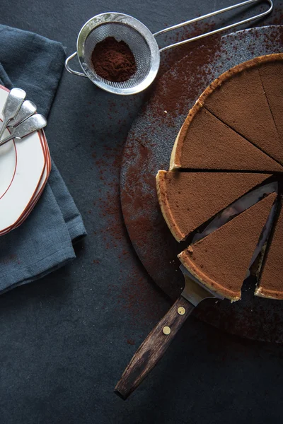 Torta de chocolate fatiado no fundo escuro — Fotografia de Stock