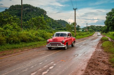 Kırmızı eski Amerikan otomobil sürücü Küba dağlarında kırsal yolda
