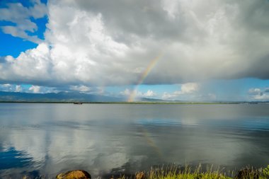 Su ve gökkuşağı göl yansıması üzerinde bulutlar
