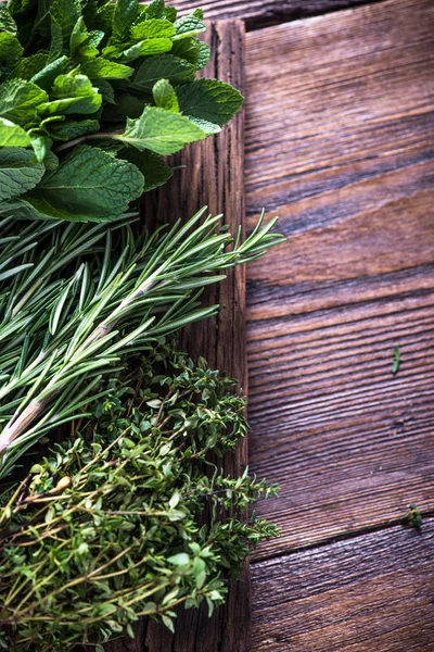 Frische aromatische Kräuter auf Holzgrund — Stockfoto