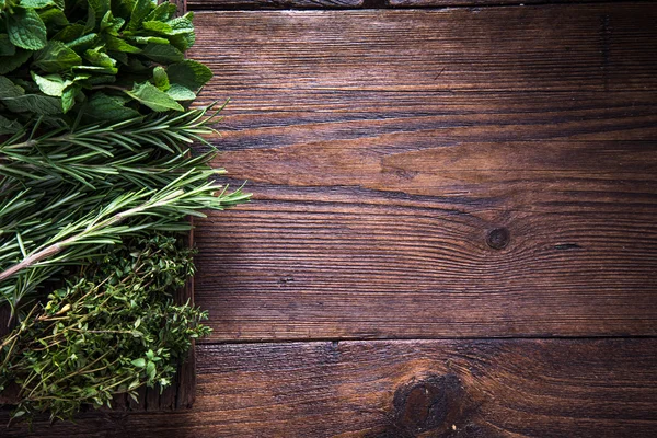 Frische aromatische Kräuter auf Holzgrund — Stockfoto