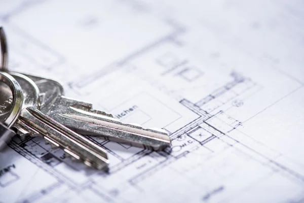 Key for new house on architect drawings — Stock Photo, Image