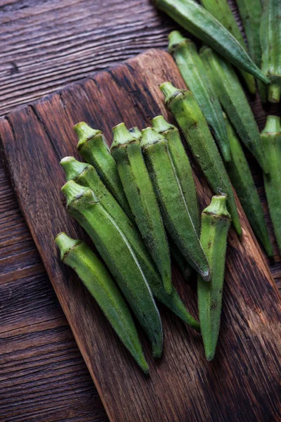 Verse okra op houten bord — Stockfoto