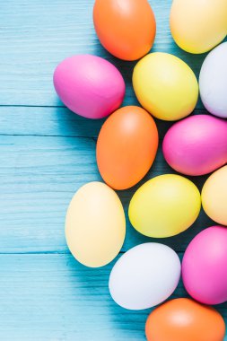 Ahşap masa üzerinde pastel renklerde Paskalya yumurtaları